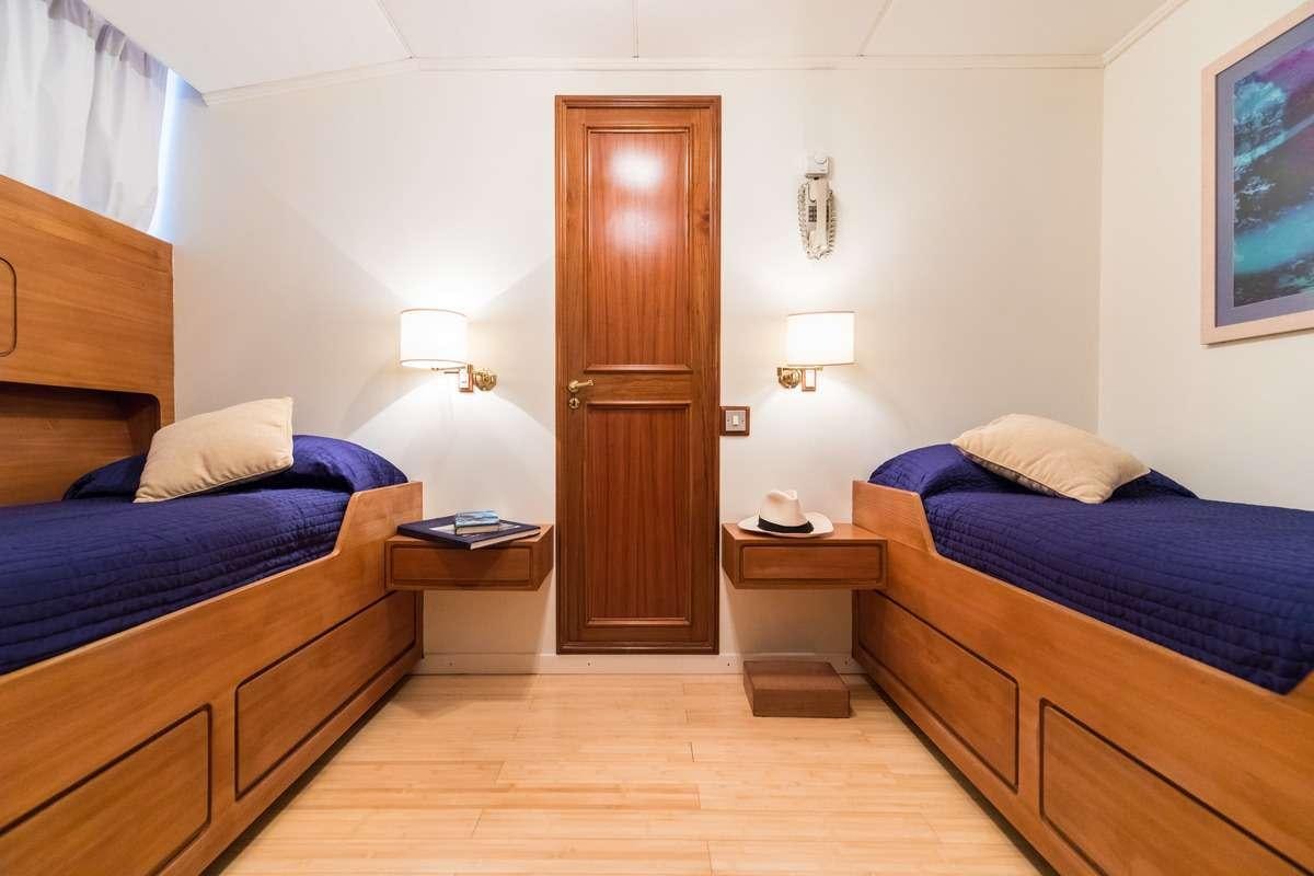 a bedroom with a bed and a wood door aboard Nafisa Yacht for Charter