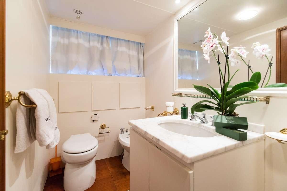 a bathroom with a sink toilet and a mirror aboard Nafisa Yacht for Charter