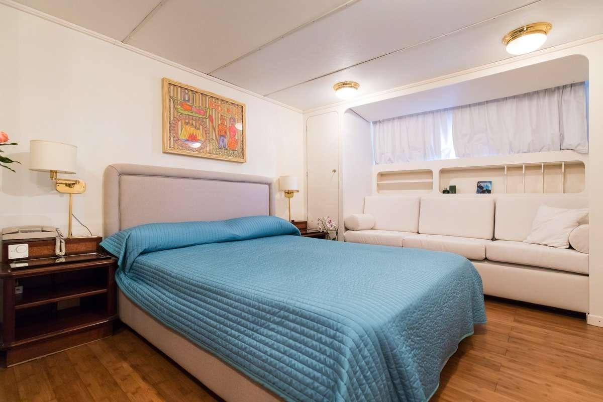 a bedroom with a bed and a couch aboard Nafisa Yacht for Charter