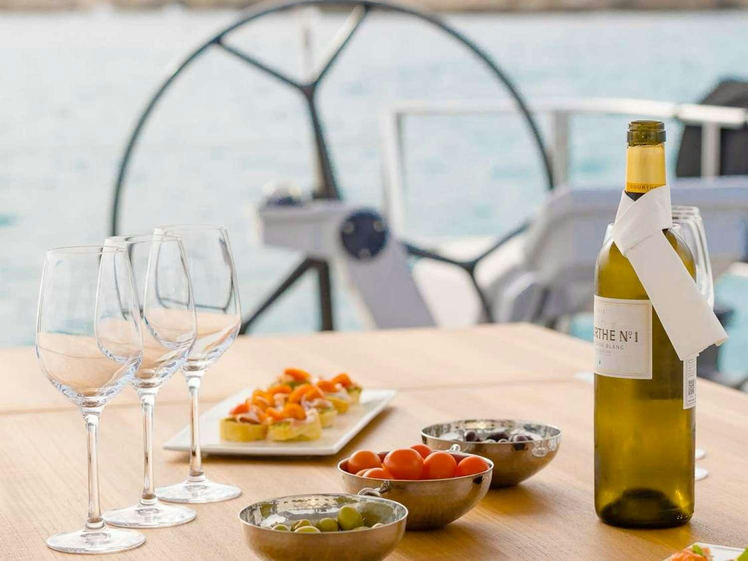 a table with food and wine aboard J SIX Yacht for Charter