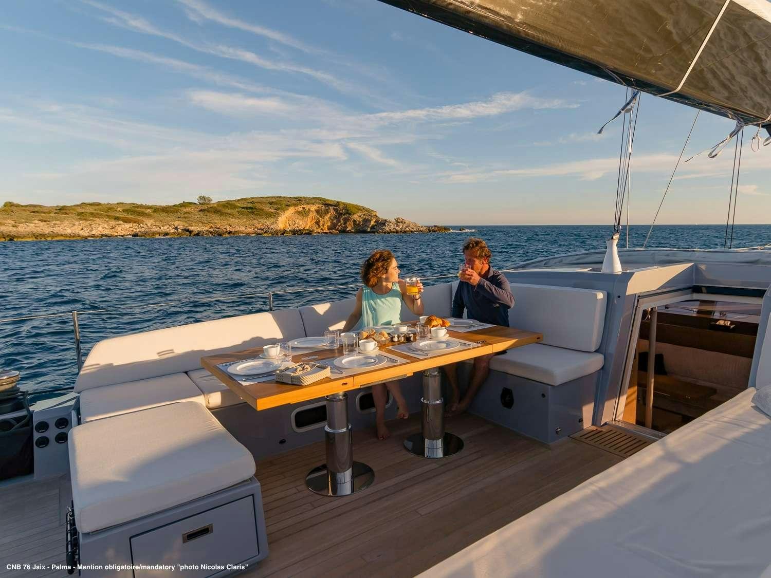 a group of people sitting at a table on a boat aboard J SIX Yacht for Charter