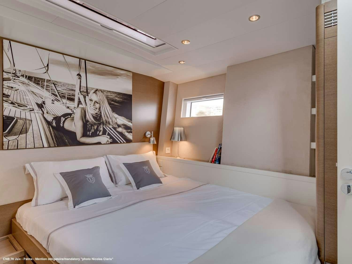 a bedroom with a bed and a painting on the wall aboard J SIX Yacht for Charter