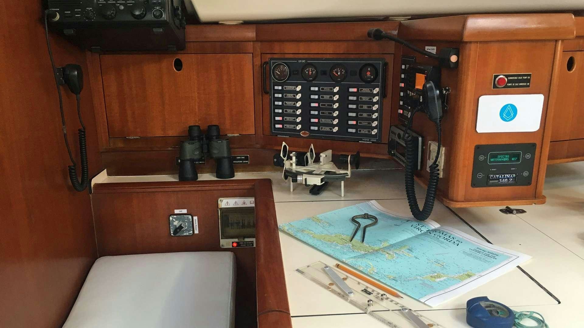 a room with a computer and a table with a map on it aboard NEMO SY Yacht for Charter