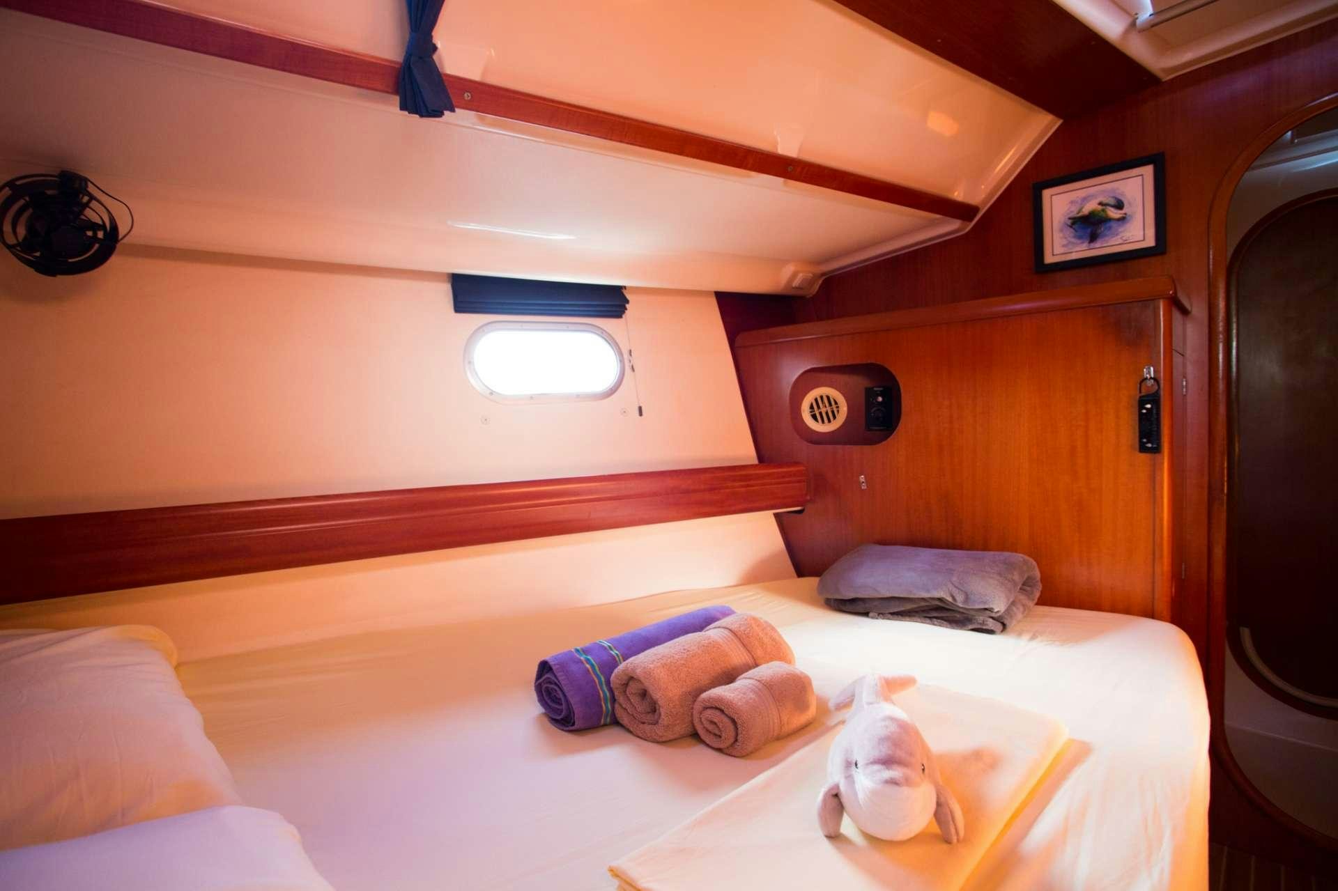 a bedroom with a bed and a shelf aboard NEMO SY Yacht for Charter