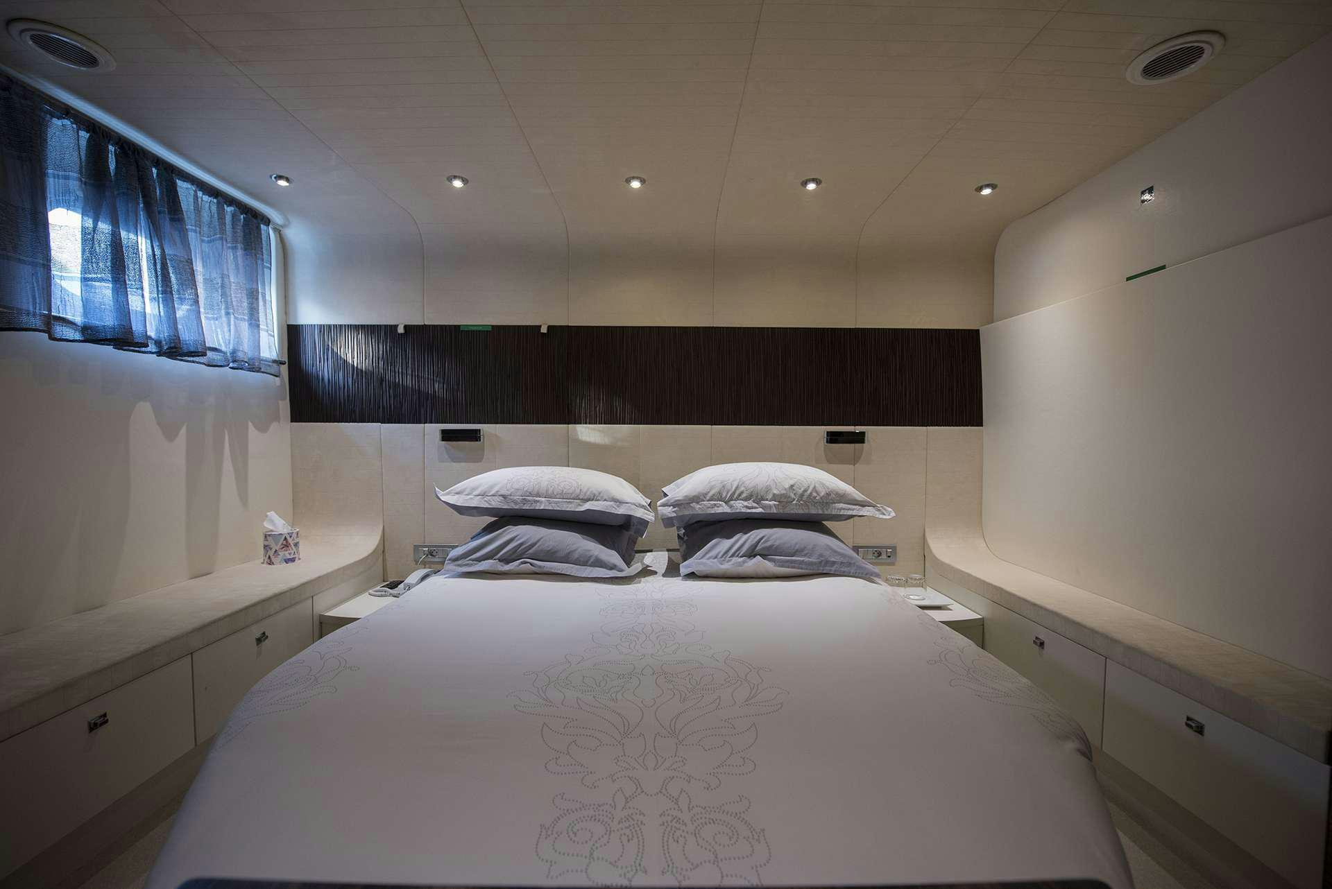 a room with a bed and a window aboard ONE BLUE Yacht for Charter