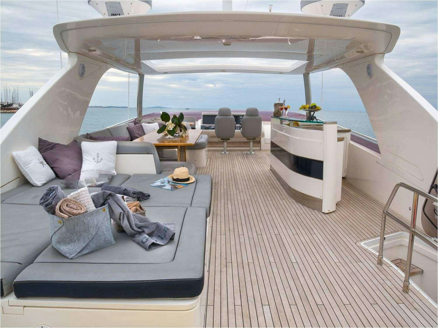 a person lying on a couch on a deck with a large white tent aboard 4LIFE Yacht for Charter