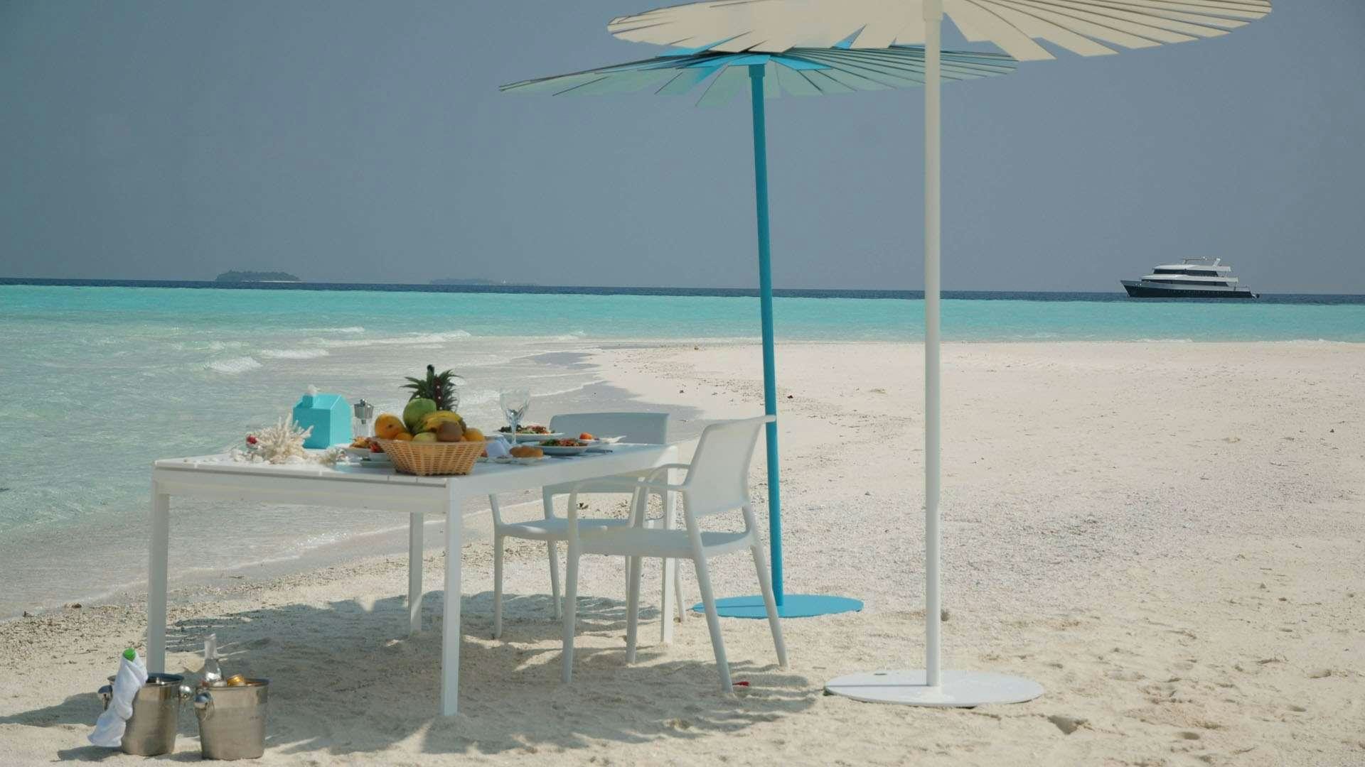 a table and chairs on a beach aboard AZALEA Yacht for Charter