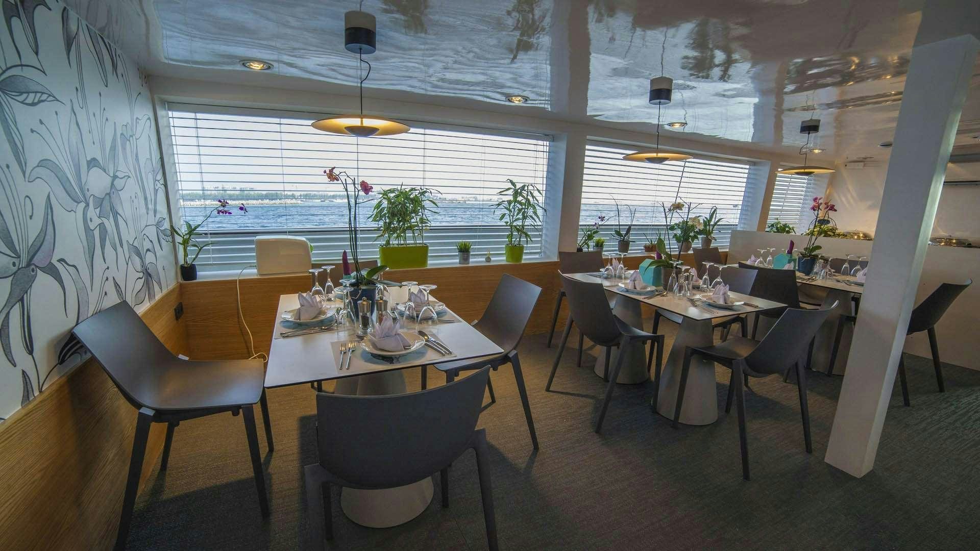 a room with tables and chairs aboard AZALEA Yacht for Charter
