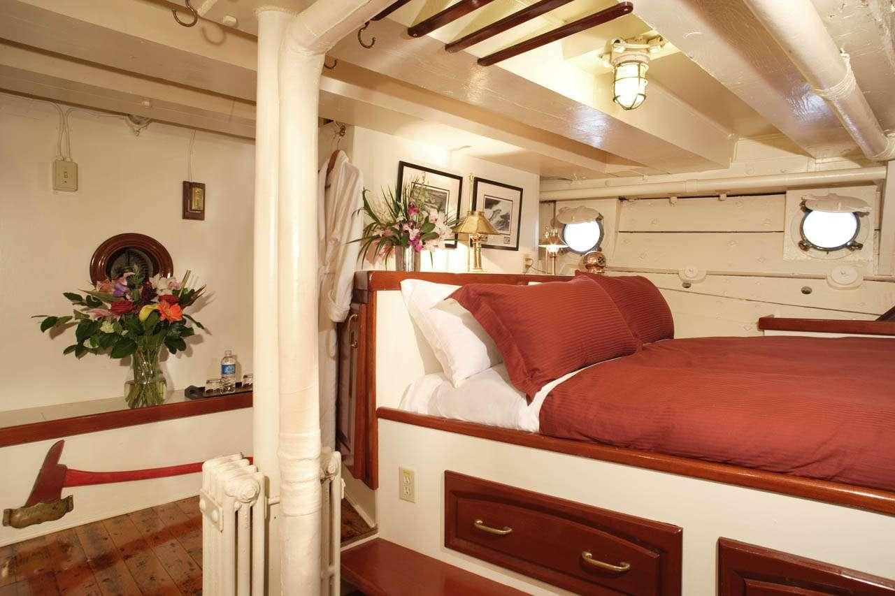 a bed with a red bed aboard PACIFIC YELLOWFIN Yacht for Charter