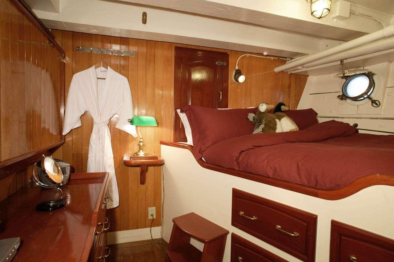 a room with a bed and a piano aboard PACIFIC YELLOWFIN Yacht for Charter