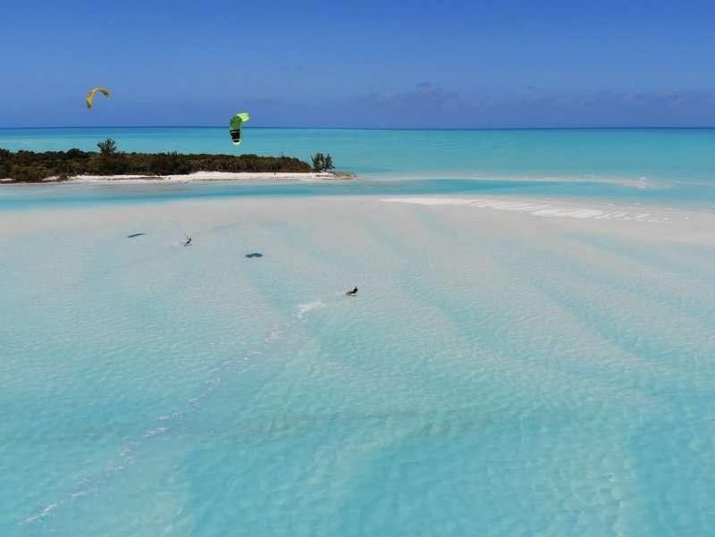 a beach with a person parasailing aboard Madrigal V Yacht for Charter