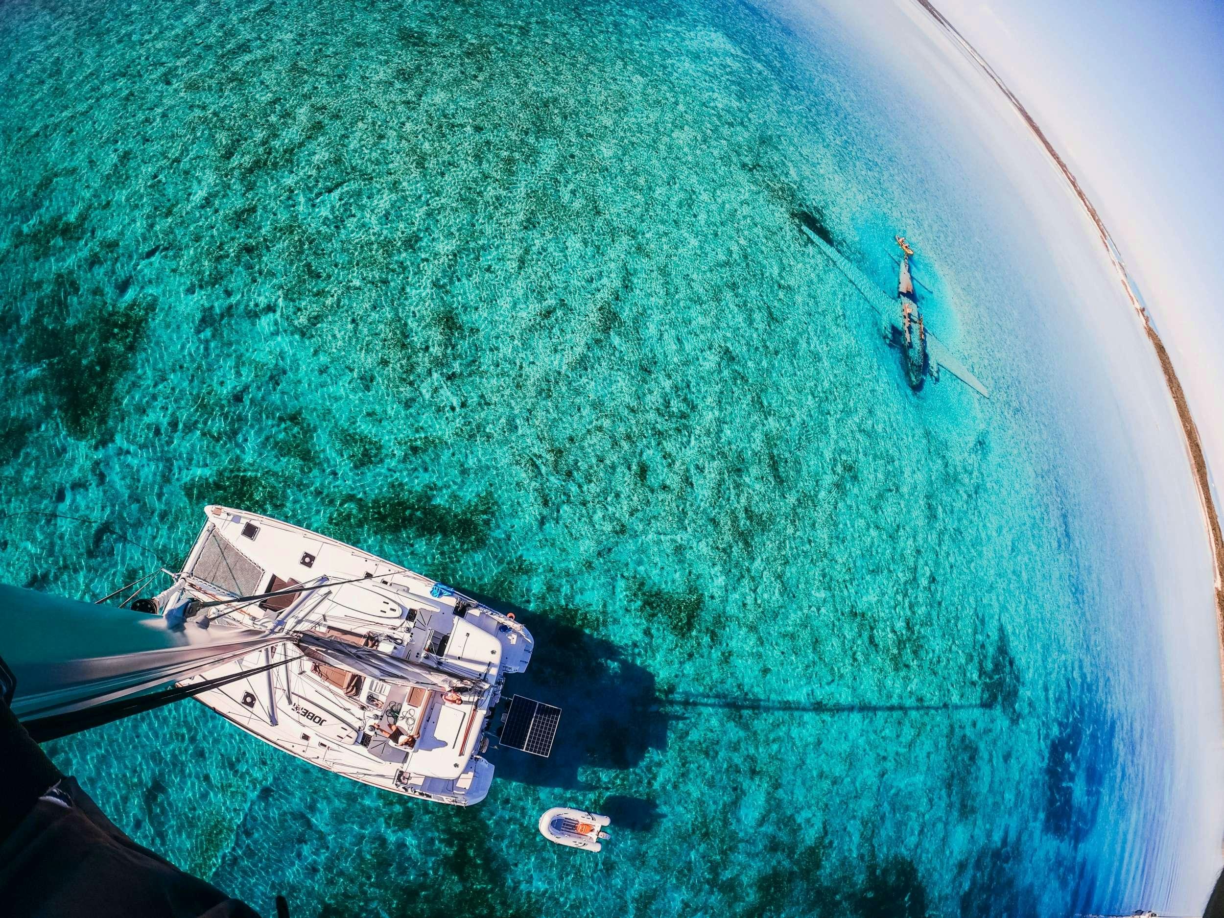 a helicopter flying over a green field aboard Madrigal V Yacht for Charter