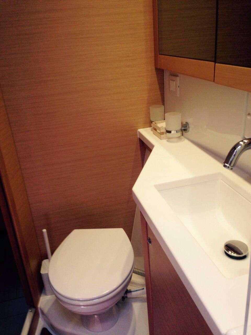 a bathroom with a toilet and sink aboard Madrigal V Yacht for Charter
