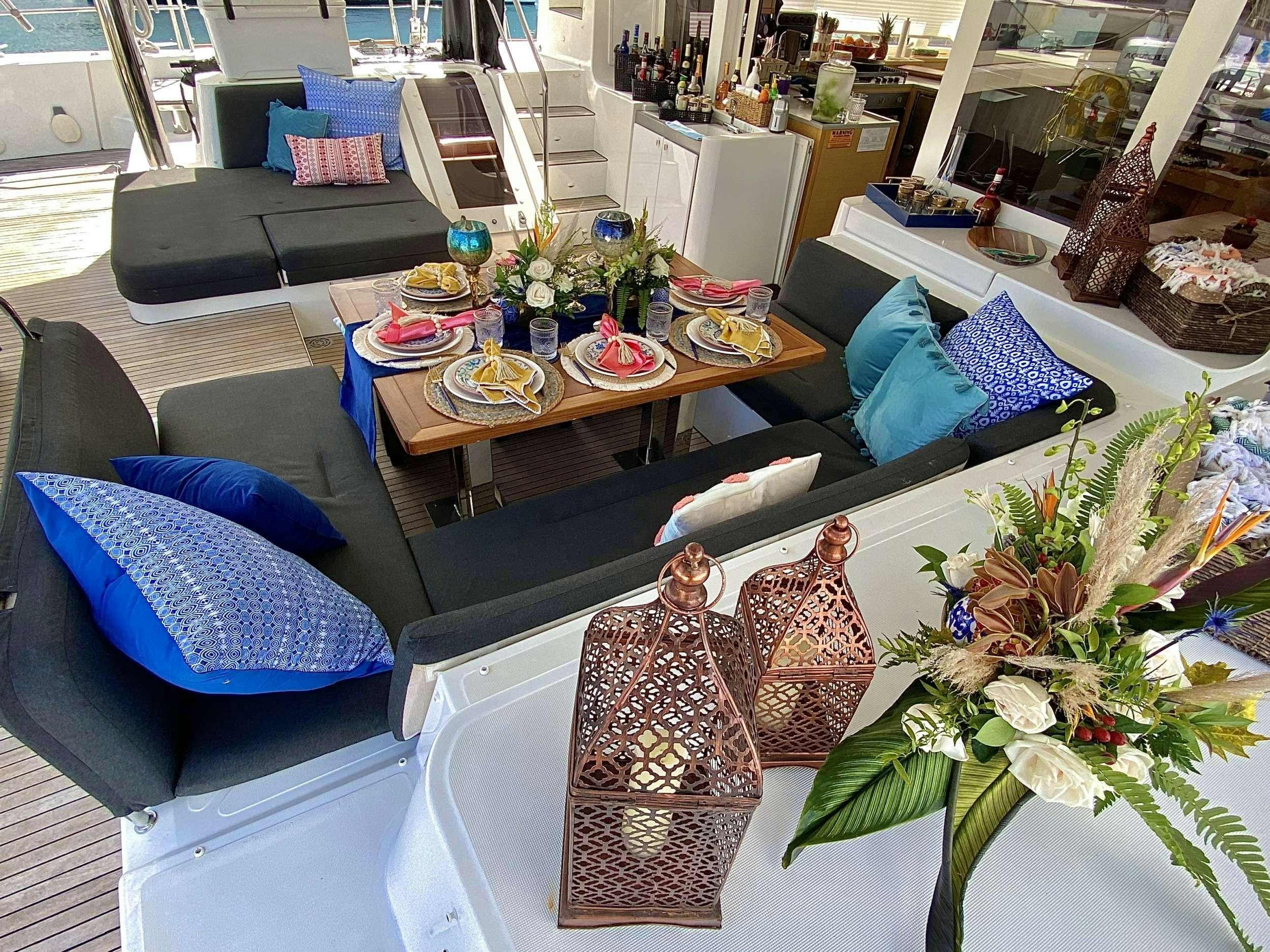 a living room with a couch and a table with food on it aboard VENTANA Yacht for Charter
