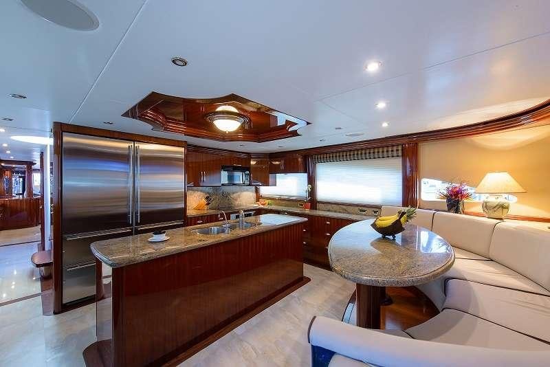 a modern looking kitchen with a bar and a dining table aboard BELLA CONTESSA Yacht for Charter