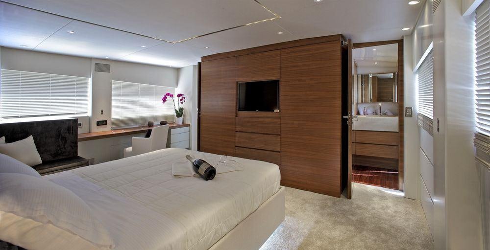 a bedroom with a bed and a television aboard TROPICANA Yacht for Charter