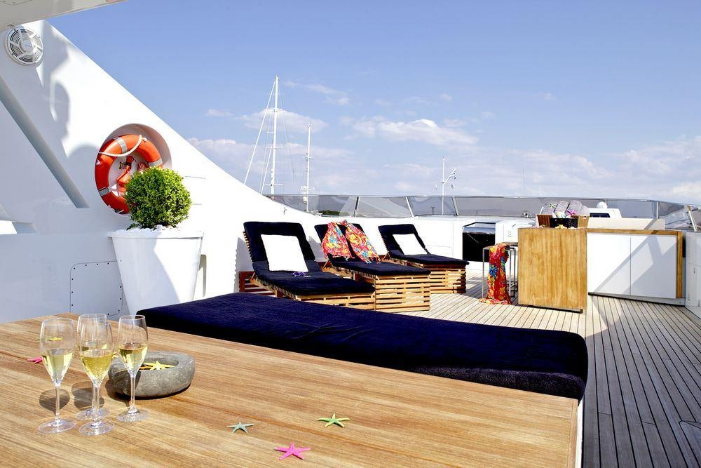 a table with wine glasses and a laptop on it aboard TROPICANA Yacht for Charter