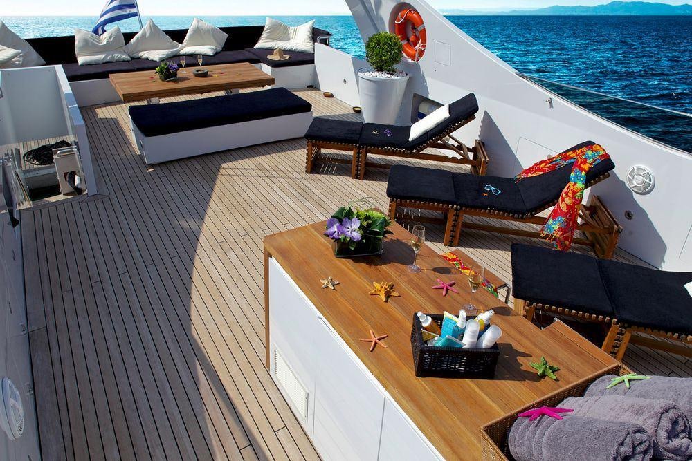 a deck with a table and chairs aboard TROPICANA Yacht for Charter