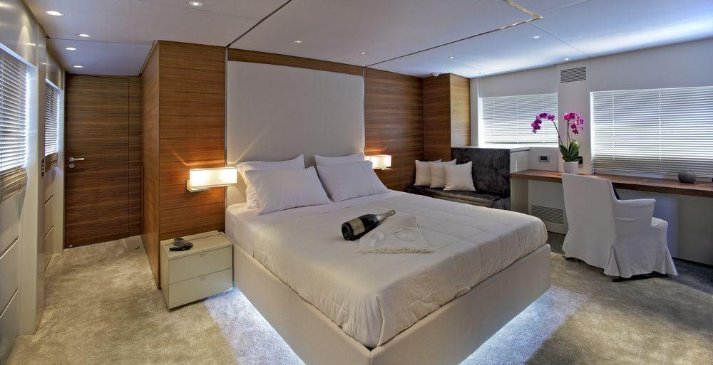a room with a bed and a desk aboard TROPICANA Yacht for Charter