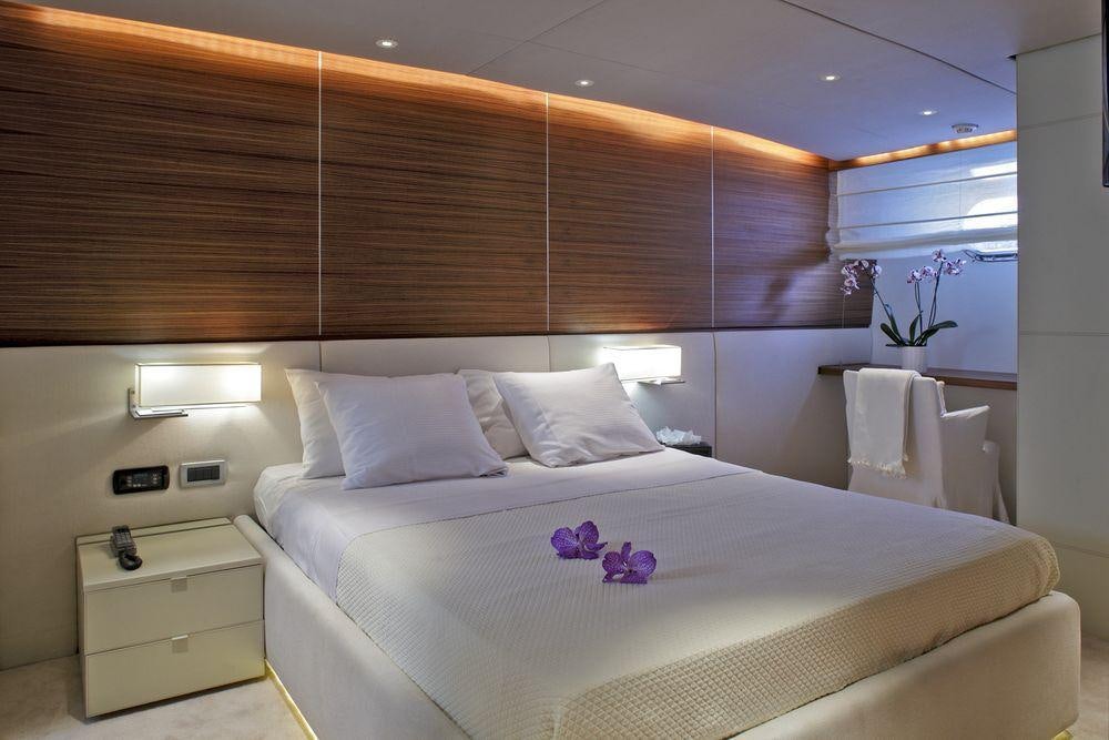 a bed with white sheets and pillows aboard TROPICANA Yacht for Charter