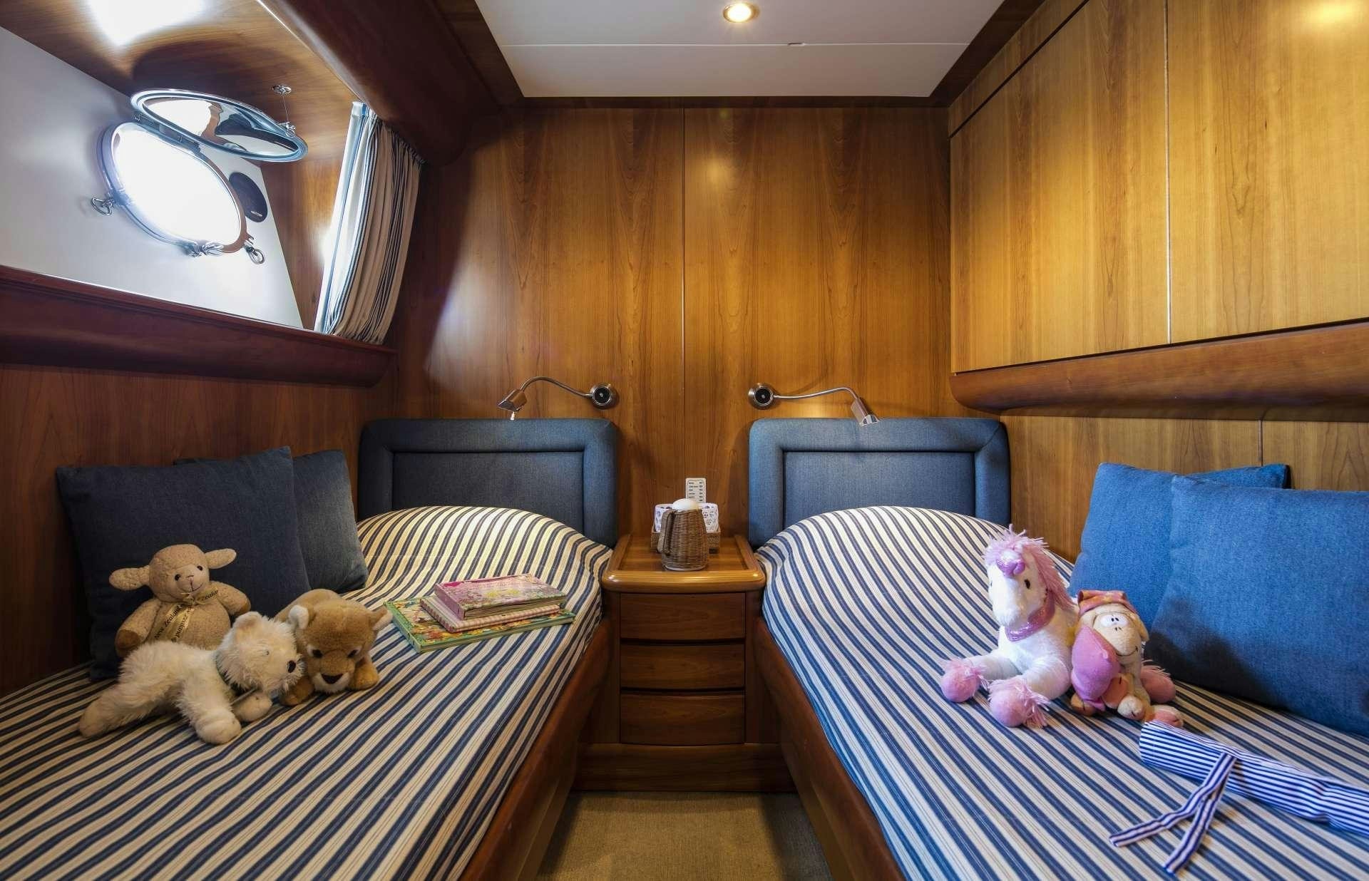 a room with a couple of beds and stuffed animals aboard VYNO Yacht for Charter