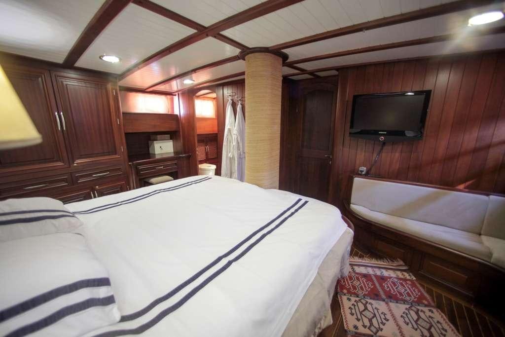 a room with a bed and a television aboard AREA Yacht for Charter
