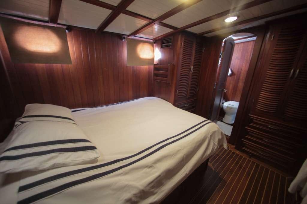 a bed with white sheets aboard AREA Yacht for Charter