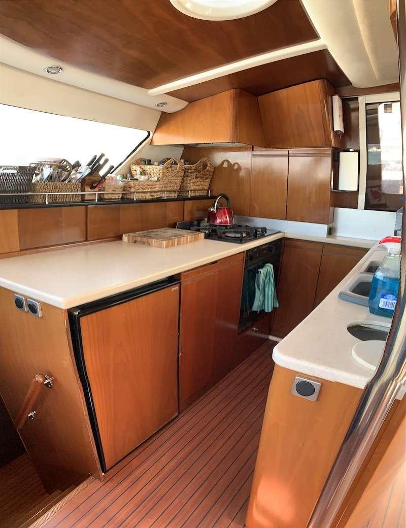 a kitchen with wooden cabinets aboard VIVO Yacht for Charter