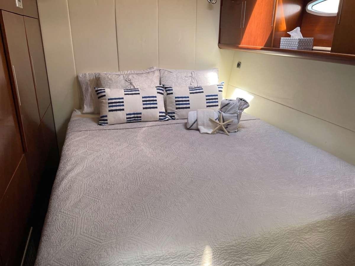 a bed with white sheets aboard VIVO Yacht for Charter