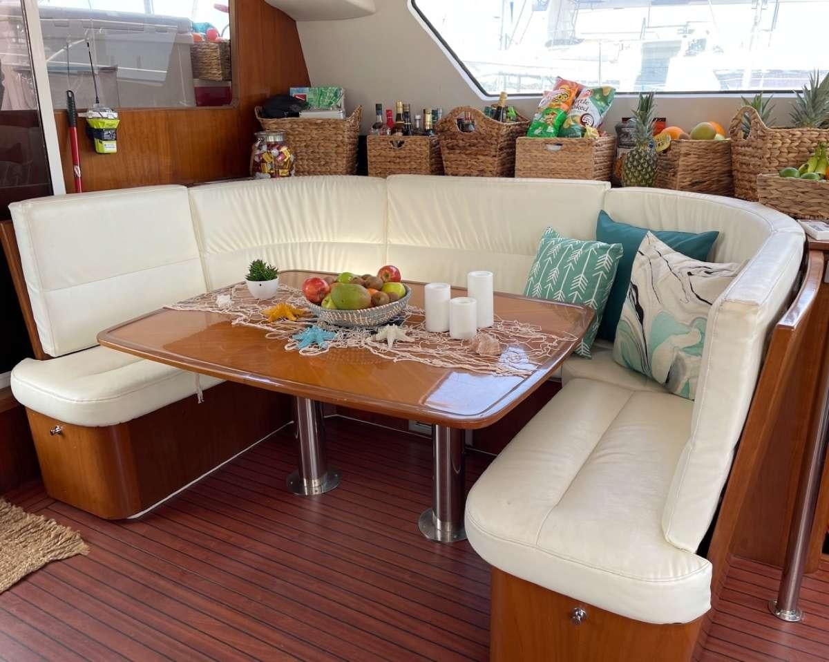 a table with a couch and a chair aboard VIVO Yacht for Charter