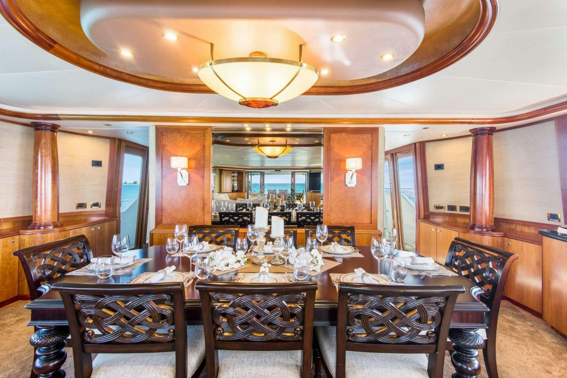 a large dining room with a chandelier aboard PIPE DREAMS Yacht for Charter