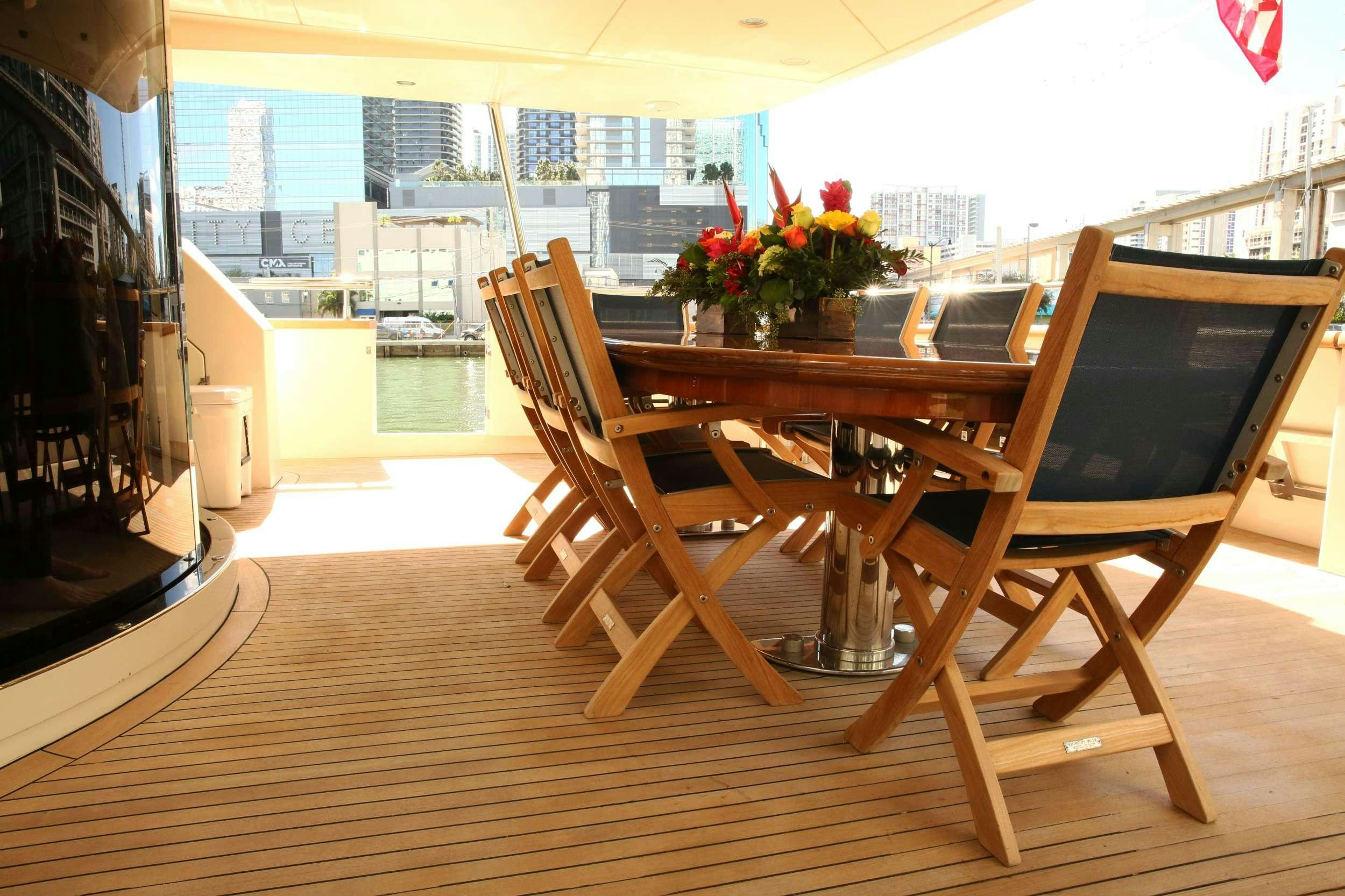 a table and chairs on a balcony aboard REFLECTIONS Yacht for Charter