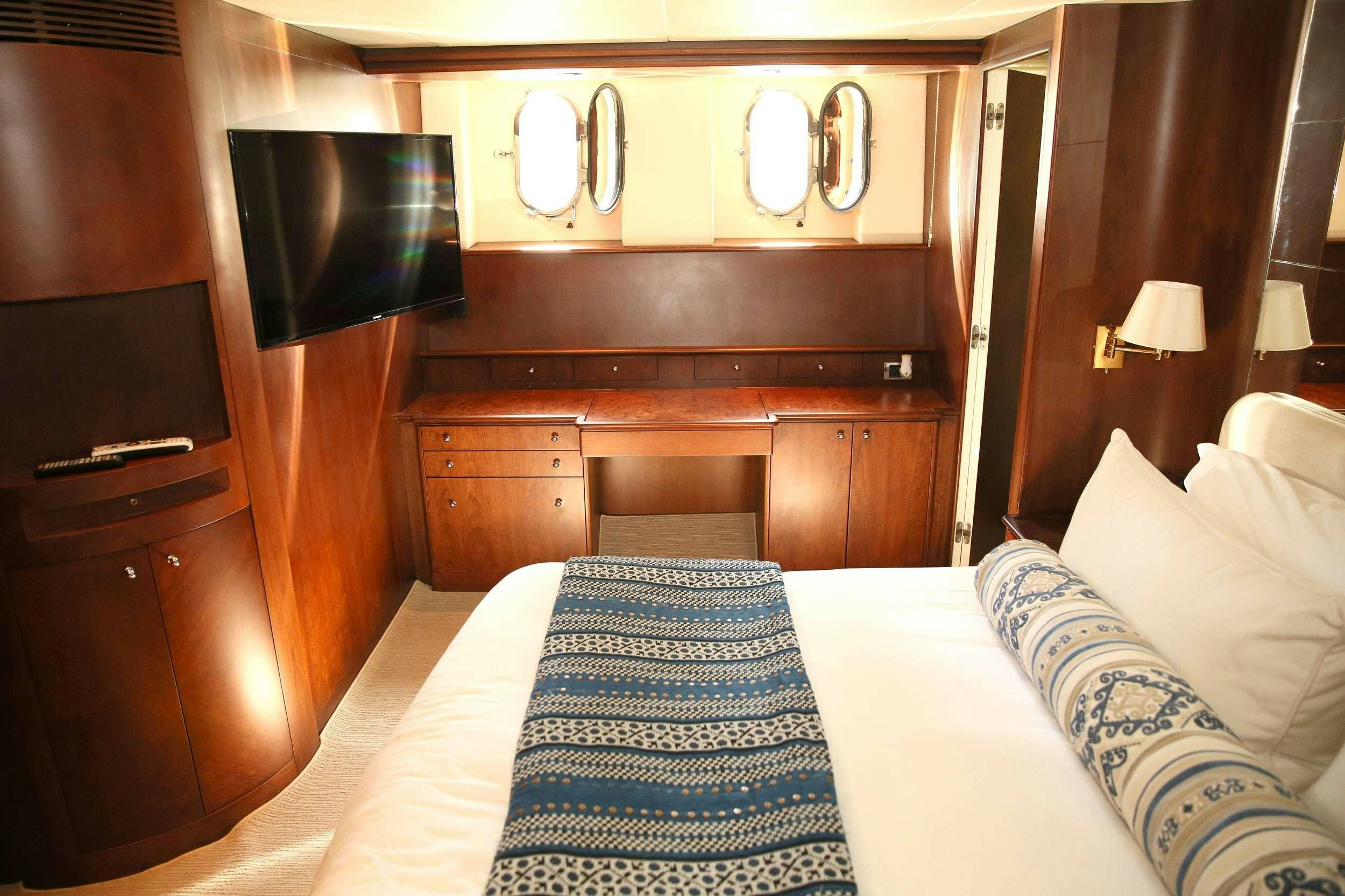 a hotel room with a bed and a television aboard REFLECTIONS Yacht for Charter