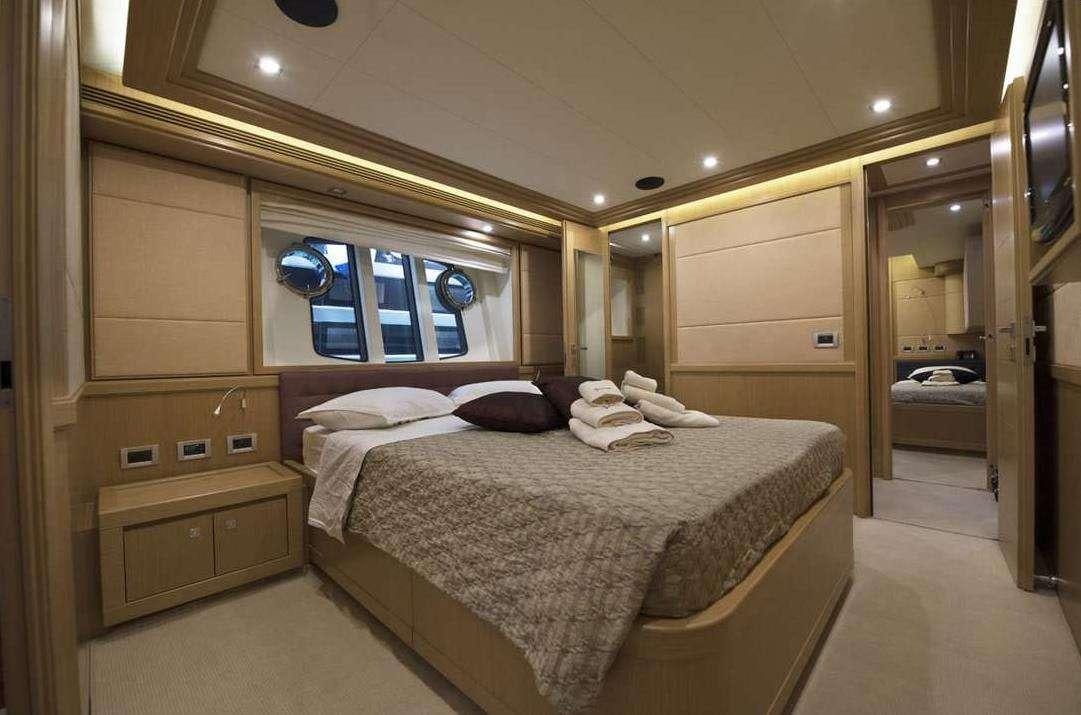 a bedroom with a bed and a mirror aboard DANA Yacht for Charter