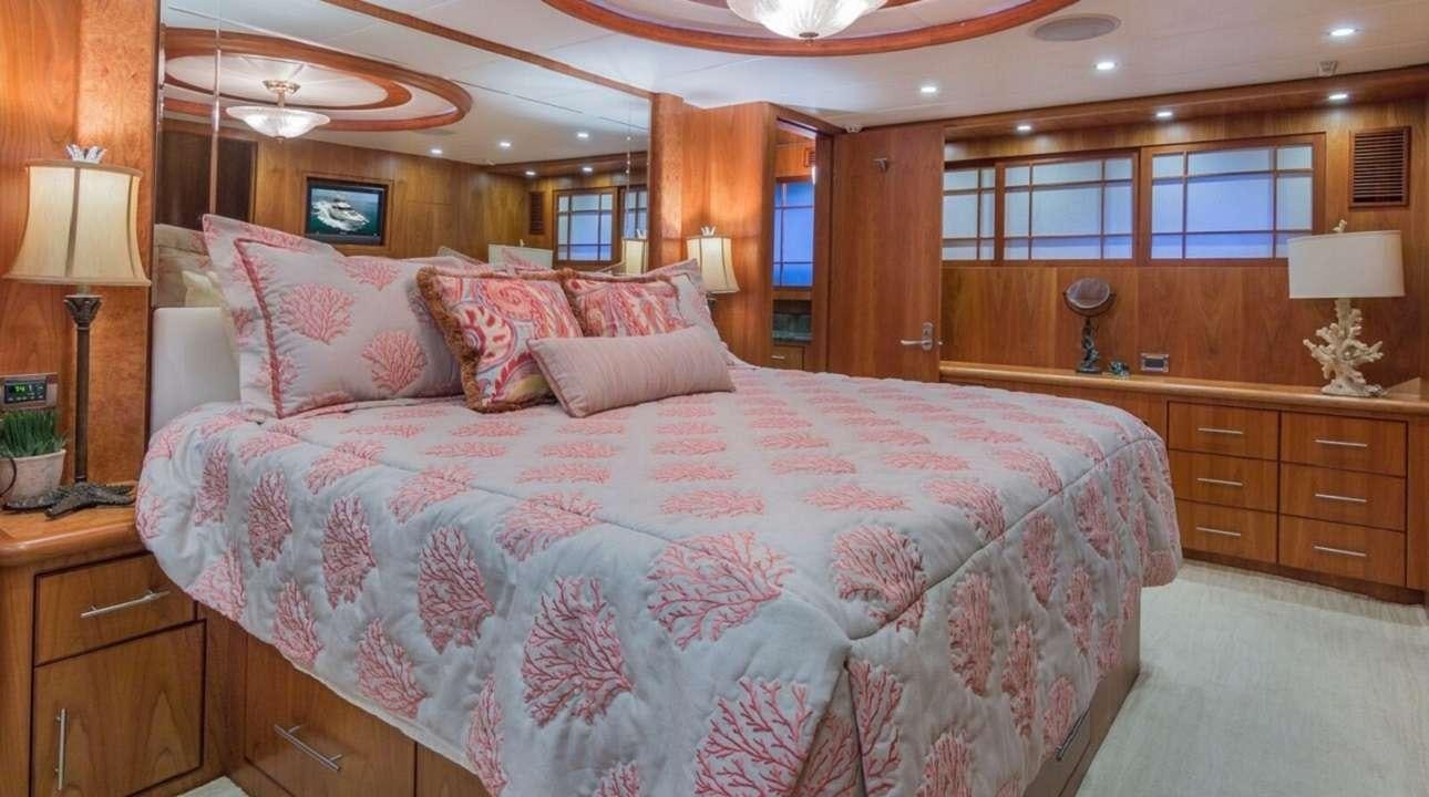 a bed with a white comforter aboard ANDIAMO Yacht for Charter