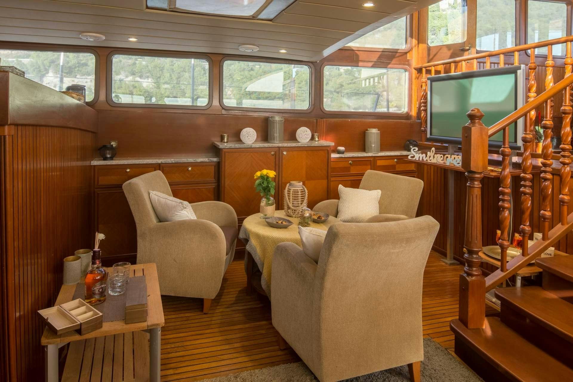 a room with a tv and furniture aboard Summer Princess Yacht for Charter