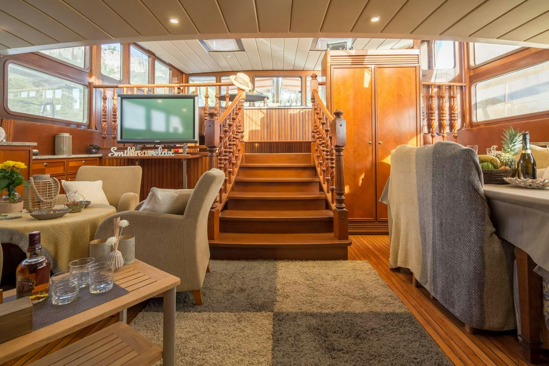 a room with a tv and furniture aboard Summer Princess Yacht for Charter