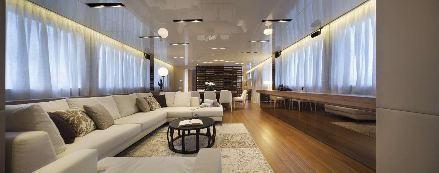 a living room with a large white couch and a table aboard INDIGO Yacht for Charter