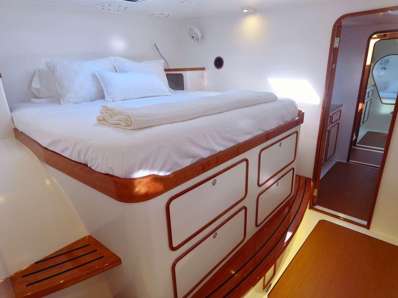 a bed with white sheets aboard SKYLARK Yacht for Charter