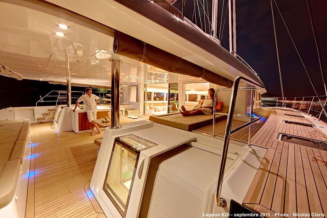 a room with a large white table and chairs and a person standing in the background aboard FIREFLY Yacht for Charter