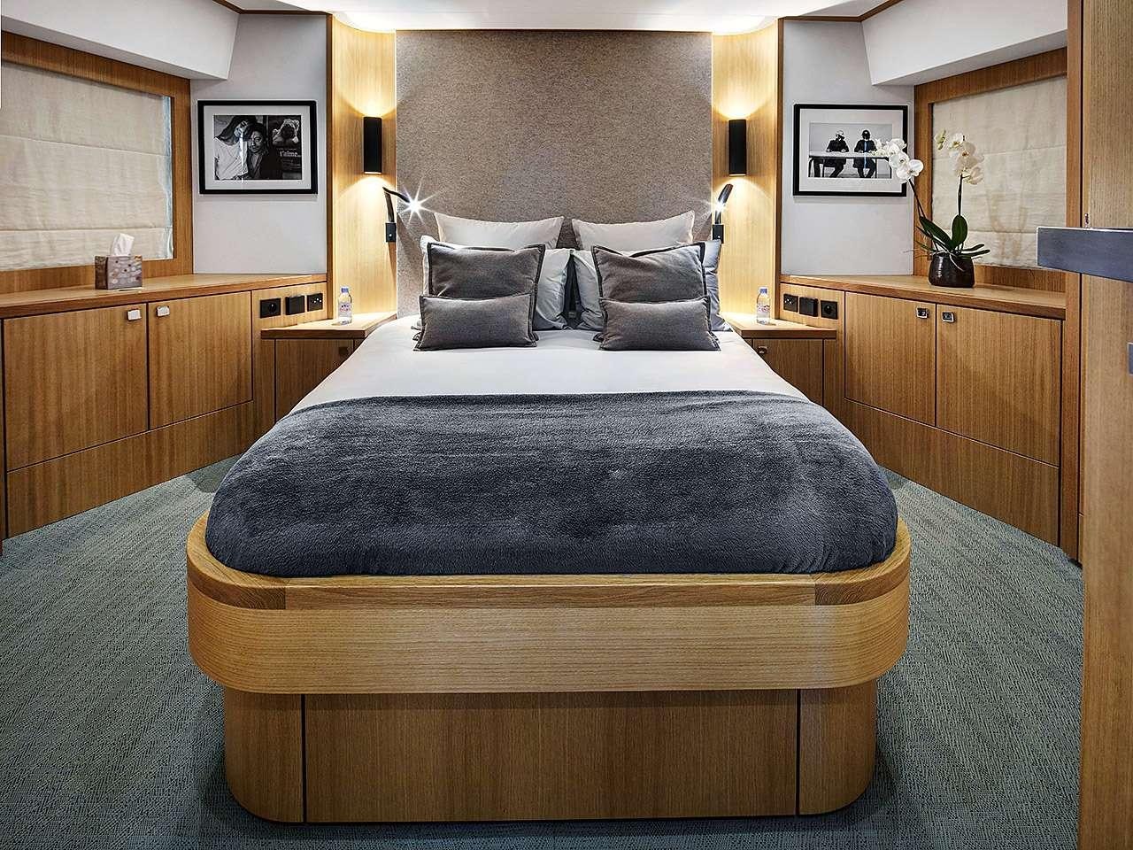 a bed with a black comforter aboard ARMONEE Yacht for Charter