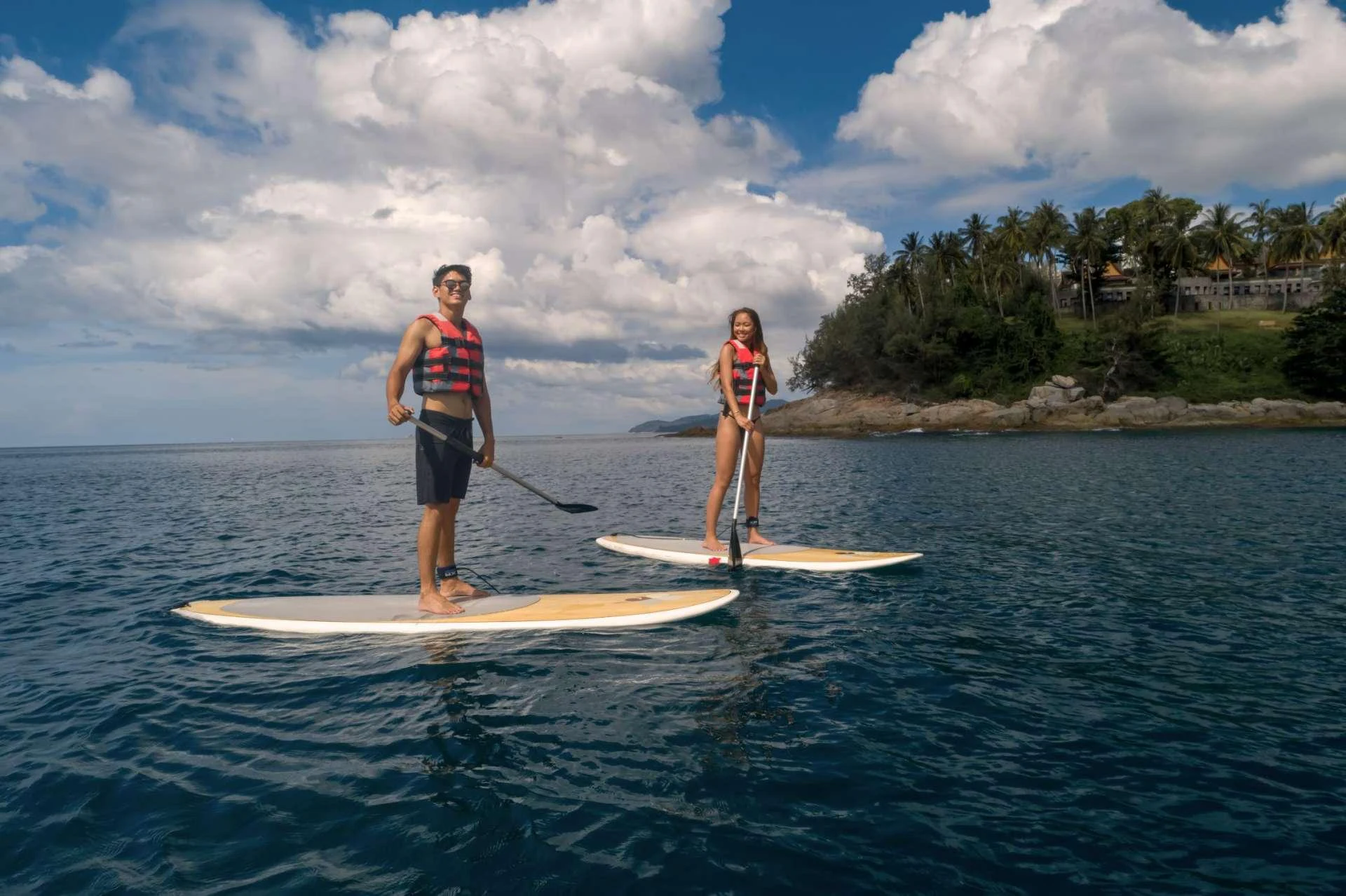 a man and woman paddle boarding aboard XANADU OF LONDON Yacht for Charter