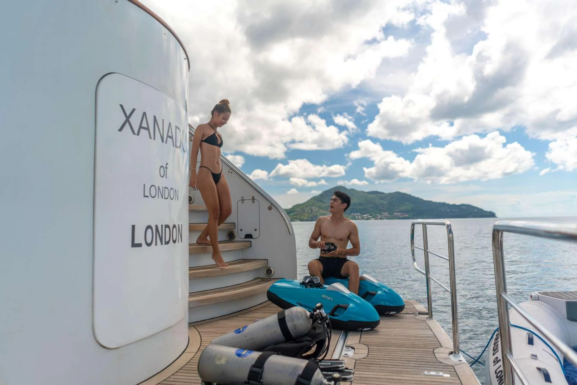 a couple of people on a dock with surfboards aboard XANADU OF LONDON Yacht for Charter