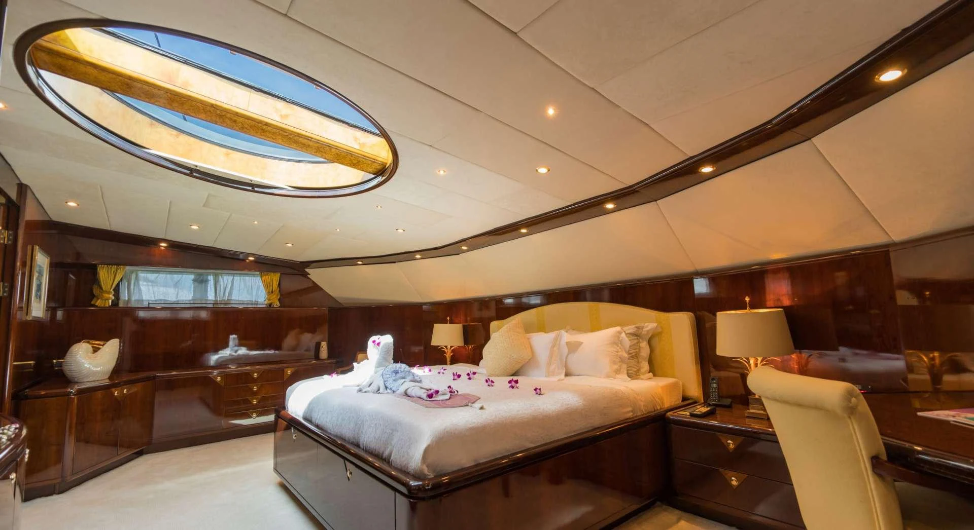 a room with a bed and a large window aboard XANADU OF LONDON Yacht for Charter