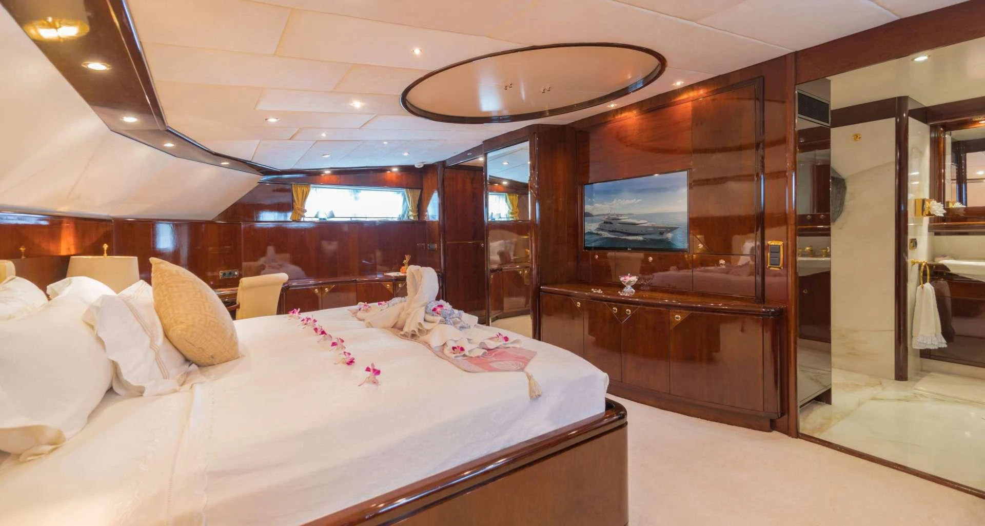 a room with a bed and a television aboard XANADU OF LONDON Yacht for Charter
