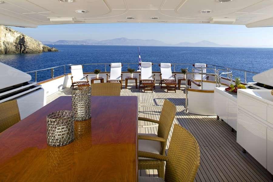 a room with a table chairs and a large body of water aboard LET IT BE Yacht for Charter
