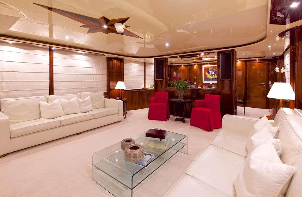 a living room with a large white couch and a table aboard LET IT BE Yacht for Charter