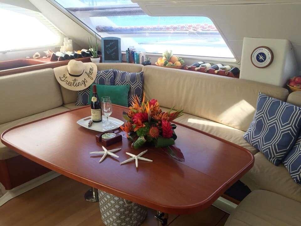 a table with a flower vase and a bottle of wine on it aboard DEEPBLUE Yacht for Charter