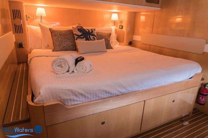 a bed with a white sheet and pillows on it aboard LUAR Yacht for Charter