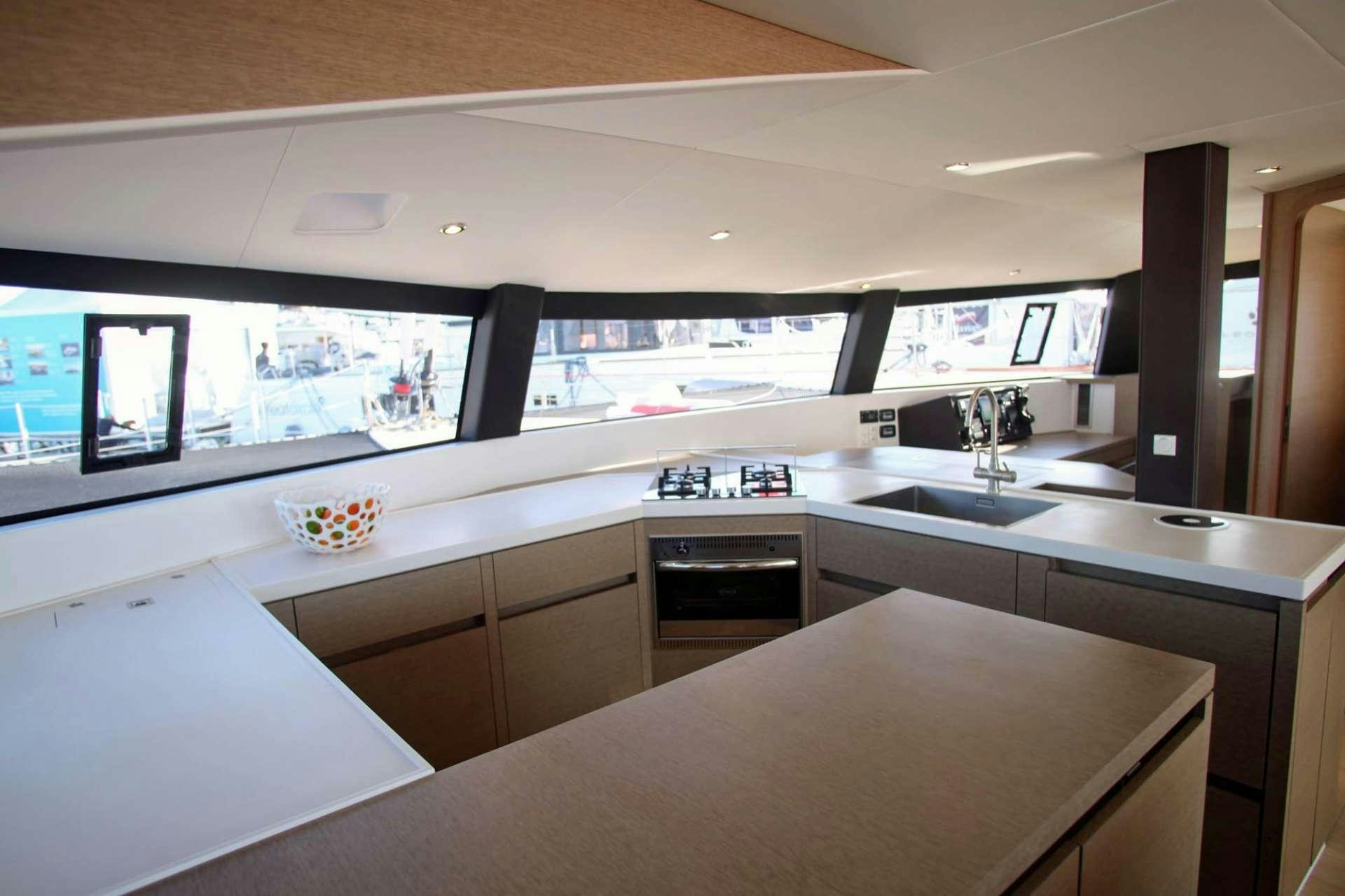 a kitchen with a large window aboard TRILOGY Yacht for Charter